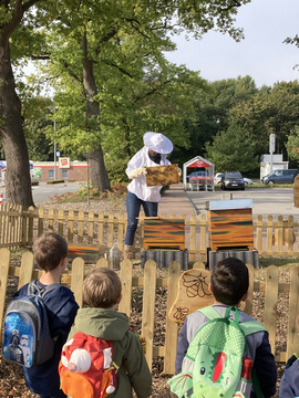 Kinder bekommen die Bienenhäuser gezeigt