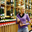Frau steht vor einem Weinregal