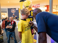 Rickey Paulding gibt einem Kind ein Autogramm