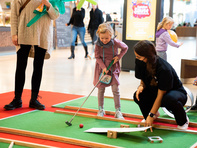 Kinder spielen Minigolf