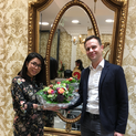 Zwei Personen präsentieren einen Blumenstrauß